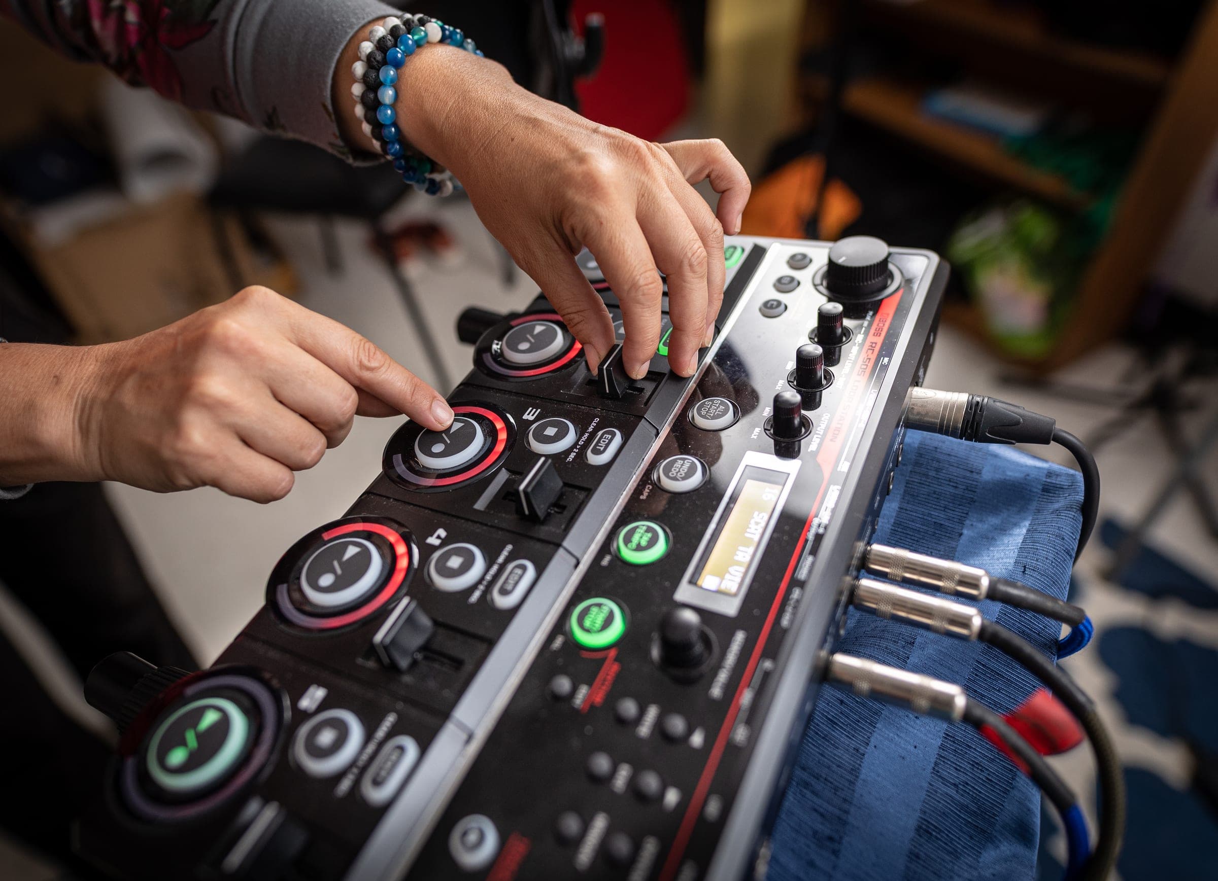 Les mains de Karine sur son looper : un doigt lance une boucle, l'autre main règle un volume.